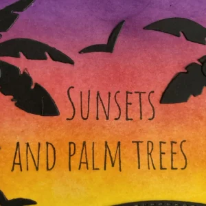 Sunsets and Palm Trees Close-up of stamped sentiment “sunset and palm trees” on handmade tropical sunset card with warm ink-blended background.
