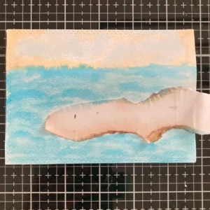 Background with mask Mermaid card background with masking paper in place, showing a soft watercolour ocean and sunset sky, ready for the sandbank and other elements to be added.