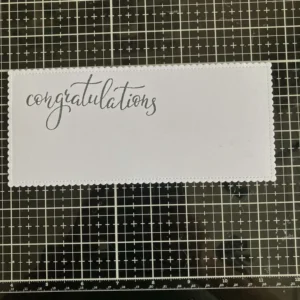 Stamped congratulations White cardstock panel with the stamped word “Congratulations” placed at the top.