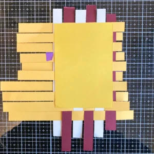 Back side of the paper weaving for a handmade fall card. A yellow cardstock panel is glued behind the woven strips to secure them. Part of the weave is visible, showing the structure from the back.