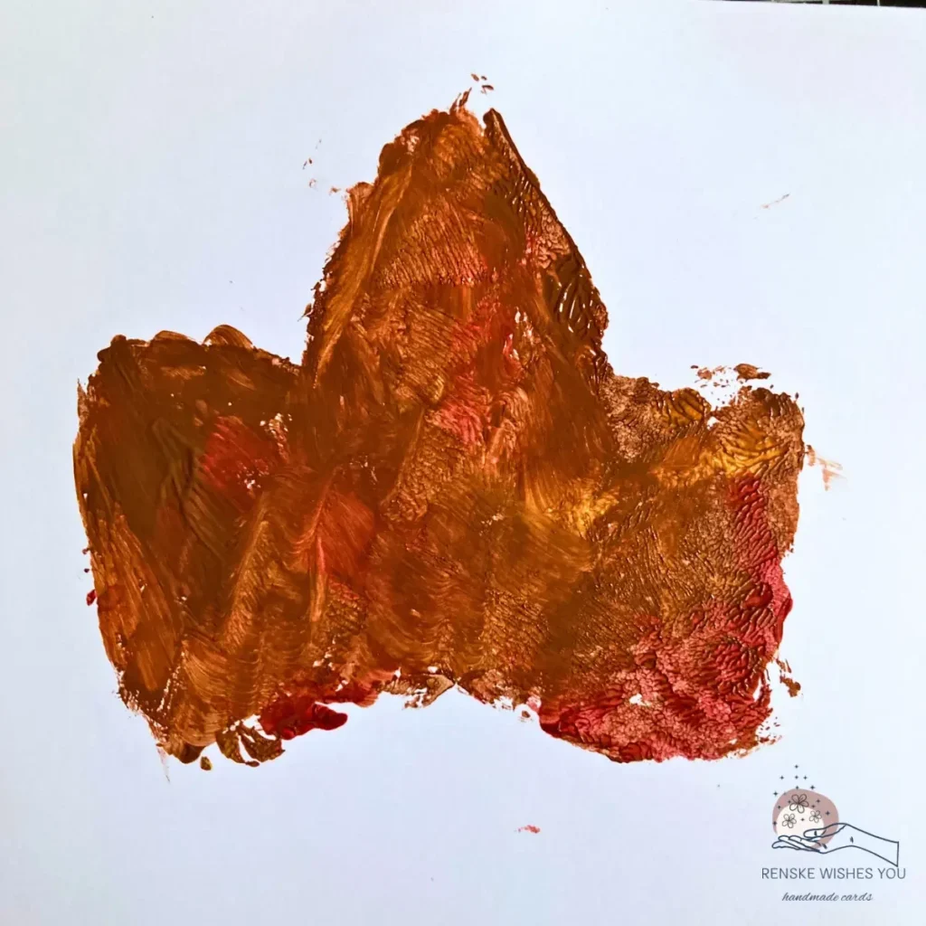 Stamped leaf print on white paper showing clear vein details and warm autumn colours for a leaf stamping card.
