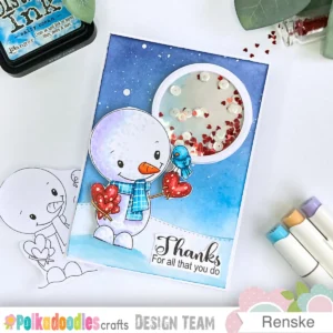 Winter Thank-you card with snowman and moon shaker (1) Overhead view of a winter thank-you card with a smiling snowman wearing a blue and pink scarf, a circular shaker moon with red and white elements, a stitched snow hill, and a blended blue night sky with white snow splatters.