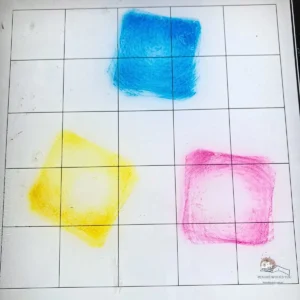 Distress Ink in blue, pink and yellow pressed onto a glass mat ready for ink smooshing technique for a watercolour background