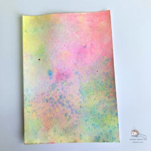 Soft watercolour background created with ink smooshing using Distress Ink in blue, pink and yellow on watercolour paper. And a little spray with acrylic paint sprays.