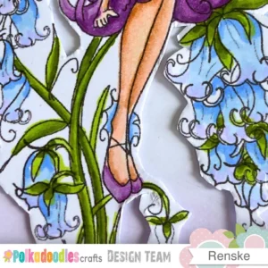 This zoomed in view shows the bottom of the girl digital stamp with her purple shoes and bluebell flowers. You can see the thin white border around the image and the gentle shadows created by the foam tape. This detail adds a manageable sense of depth to the arched background of the project.