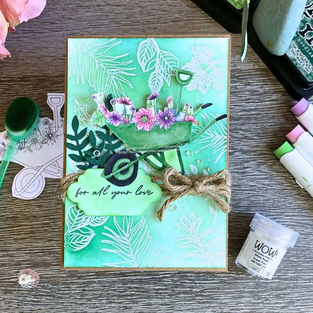 Completed green wheelbarrow card with an emboss resist background and natural twine details.