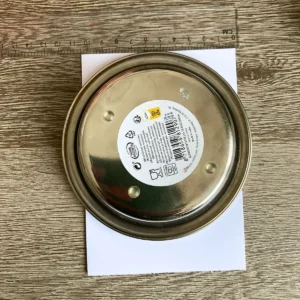An overhead view shows a round silver bowl placed on a white card base for tracing a curved top. A ruler lies at the top of the frame to help with the placement of the circle. This is an approachable step in making an arch card tutorial project with household items.