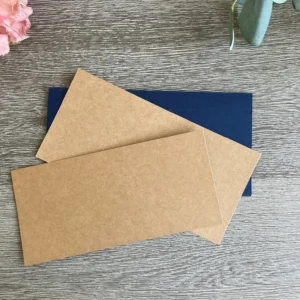 Base card layers for this Father's day card The dark blue and kraft cardstock sheets are laid out on a wooden surface . These pieces form the sturdy base for your masculine cards. This setup helps you see the scale of your project before you start cutting.