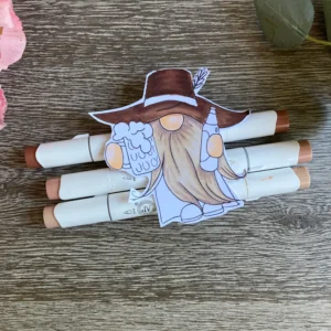 IMG_2033 Deep brown alcohol markers are used to shade the large cowboy hat . Placing the darkest tones under the brim adds immediate dimension to the focal image. This part of the gnome colouring helps the character feel three dimensional.