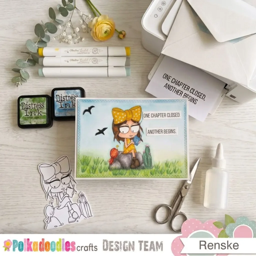 A completed landscape card featuring a coloured digital stamp of a girl reading on a rock. The background shows soft grass and blue sky created with a quiet ink blending technique.